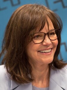 A close-up headshot of Sally Field smiling warmly. Her eyes sparkle with wit and kindness, and her ageless beauty reflects her enduring charm.