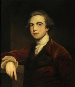 A portrait of Sir William Jones, a British man from the 18th century, wearing a judge's robe and cravat. He has a thoughtful expression on his face and is holding a book titled "Manusmriti" in his hand.